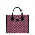 Gucci GG Supreme canvas tote bag in pink with dark leather trim and top handles.