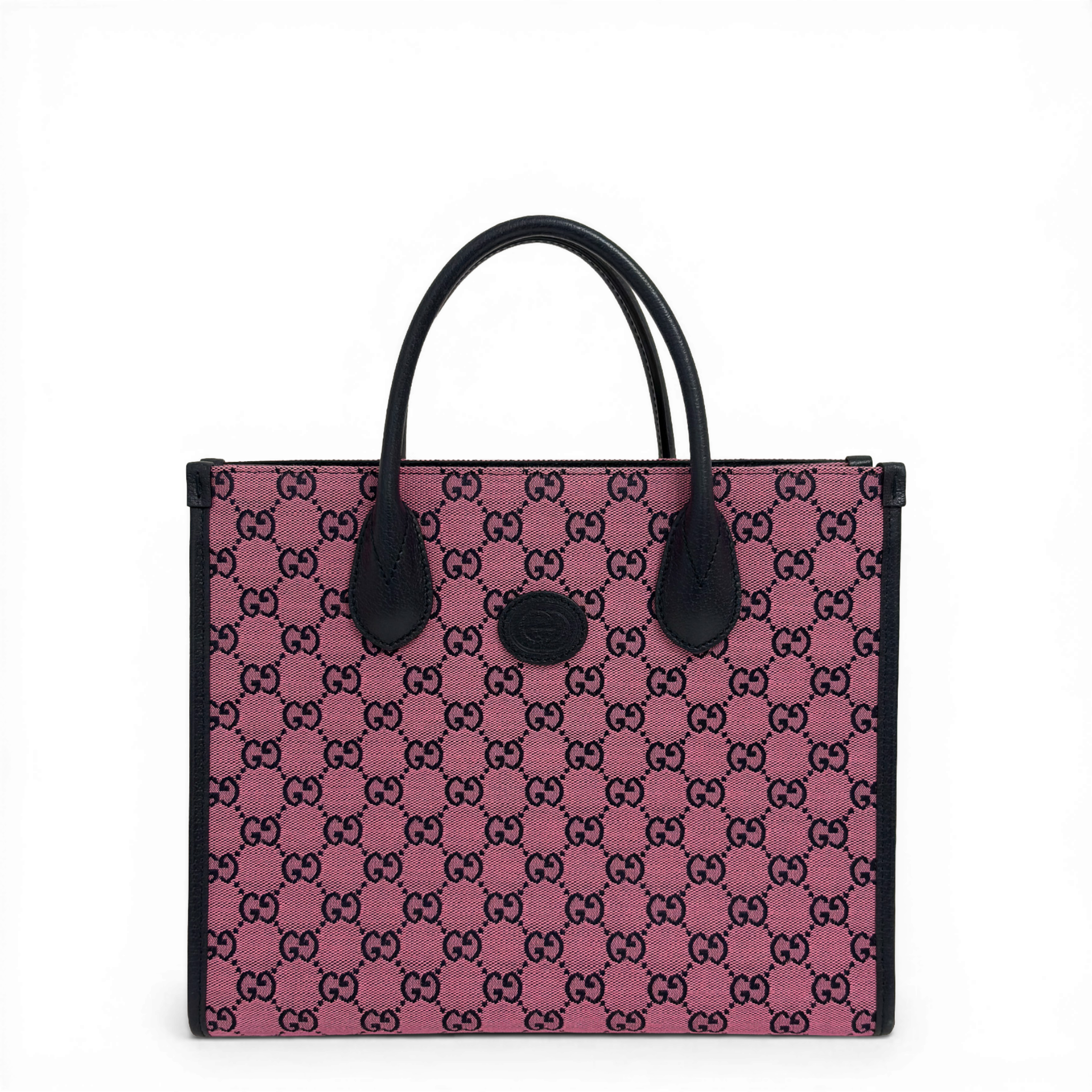 Gucci GG Supreme canvas tote bag in pink with dark leather trim and top handles.