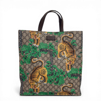 Gucci GG Supreme Tigers tote bag in beige multicolor canvas with dark brown leather trim.