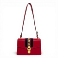 Gucci Sylvie shoulder bag in red leather with signature web stripe and gold-tone chain buckle detail.