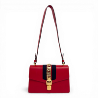 Gucci Sylvie shoulder bag in red leather with signature web stripe and gold-tone chain buckle detail.